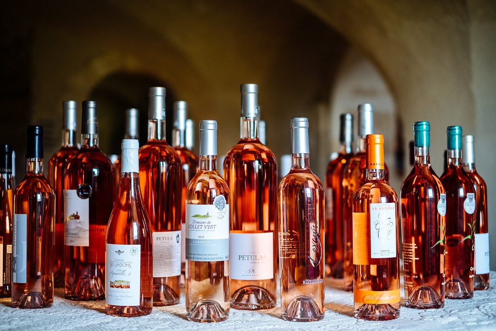 De nombreuses bouteilles de vin rosé sont alignées sur une table.