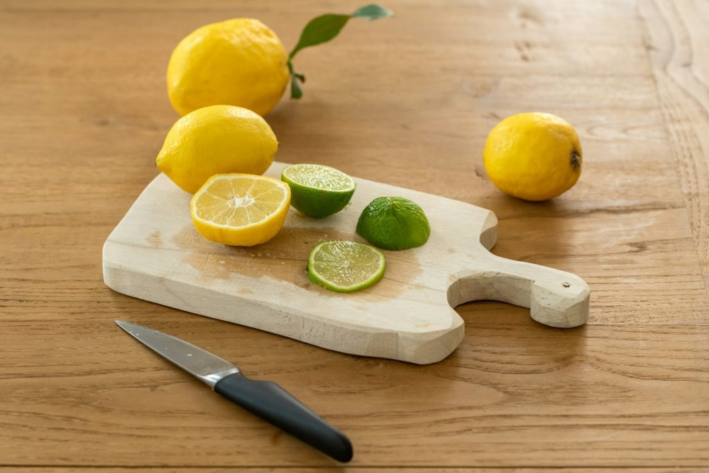 citron coupé en tranches à côté du couteau sur une planche à découper en bois brun